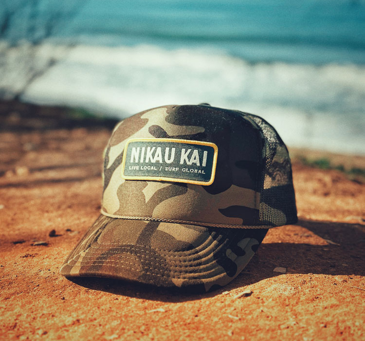 Nikau Kai branded camouflage cap on beach