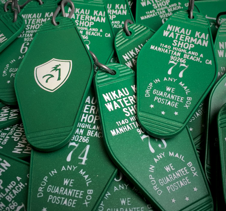 Green motel-style keychains with Nikau Kai logo